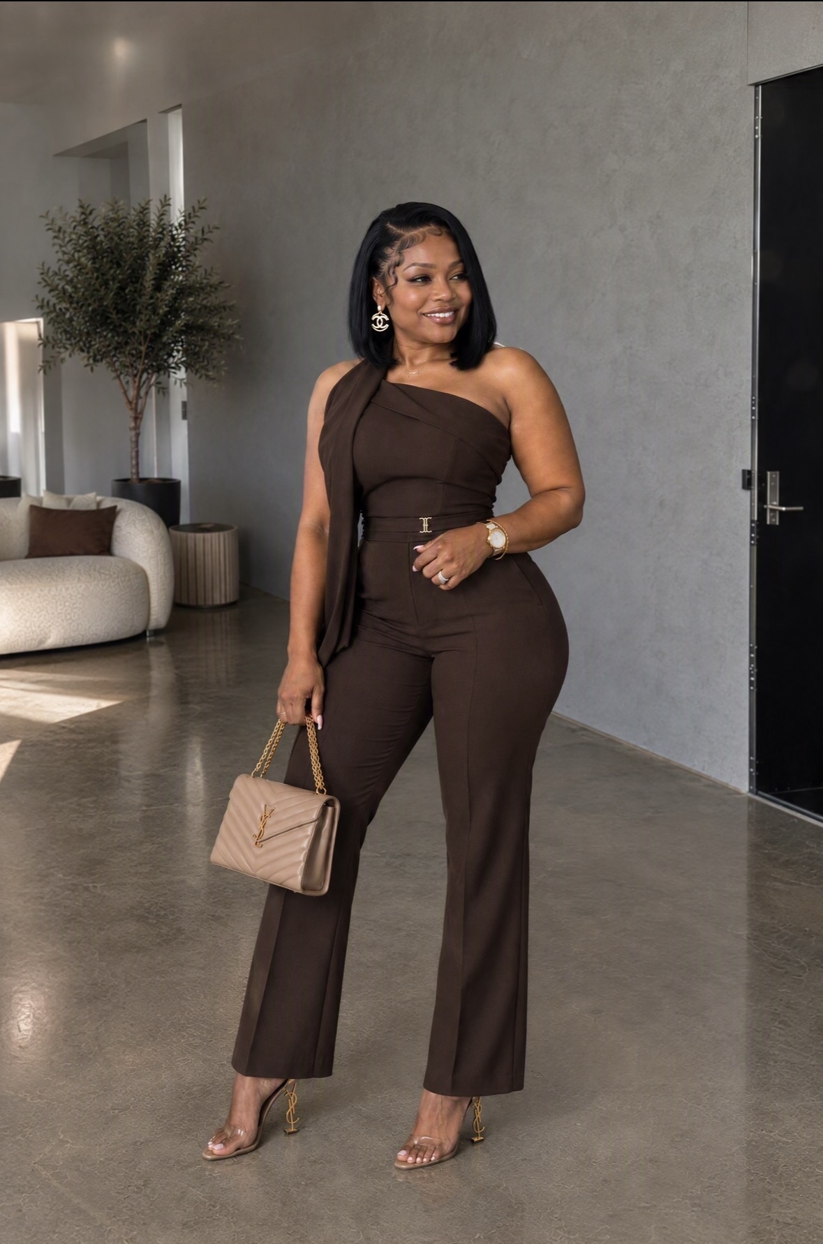 Dr. Loriane Clarke in a brown one-shoulder jumpsuit