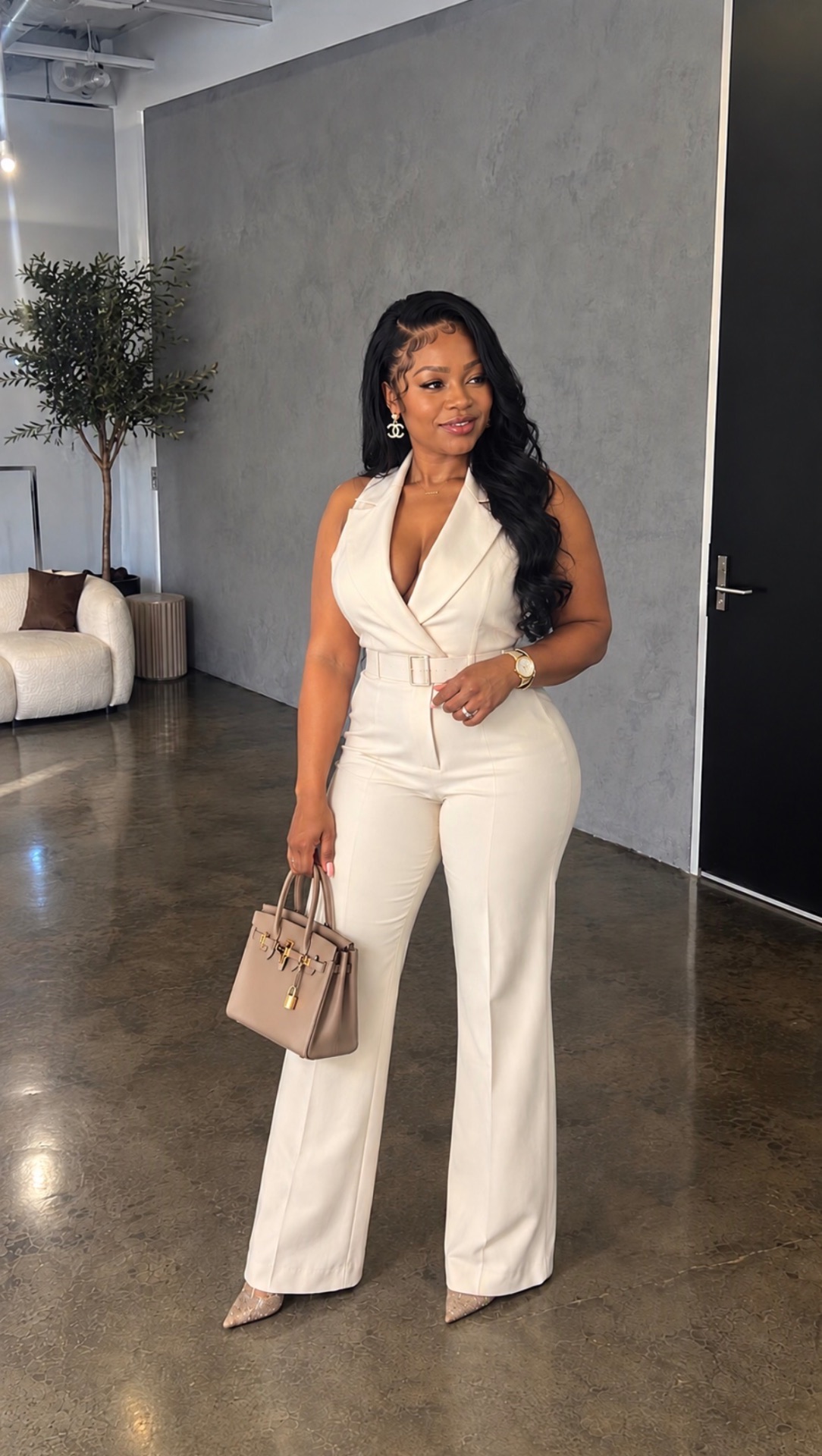 Dr. Loriane Clarke in an ivory belted jumpsuit